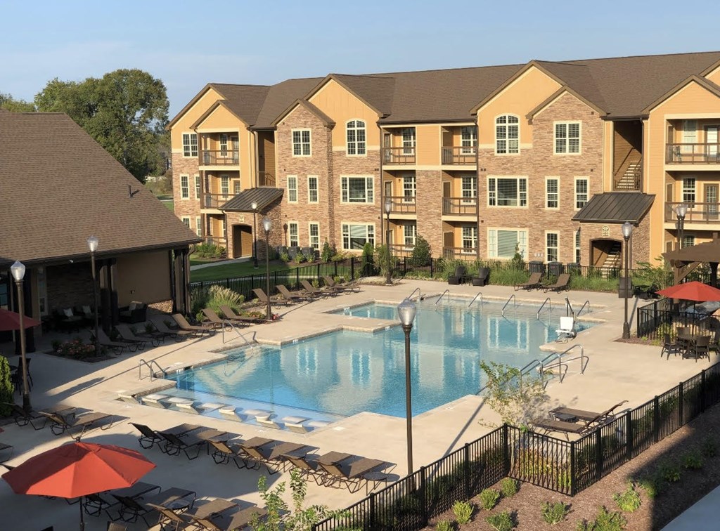 A large apartment complex with a pool and patio area.