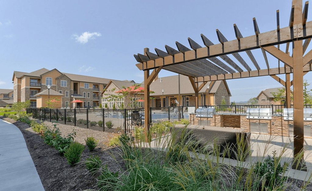 A wooden pergola is in the foreground of a residential area.