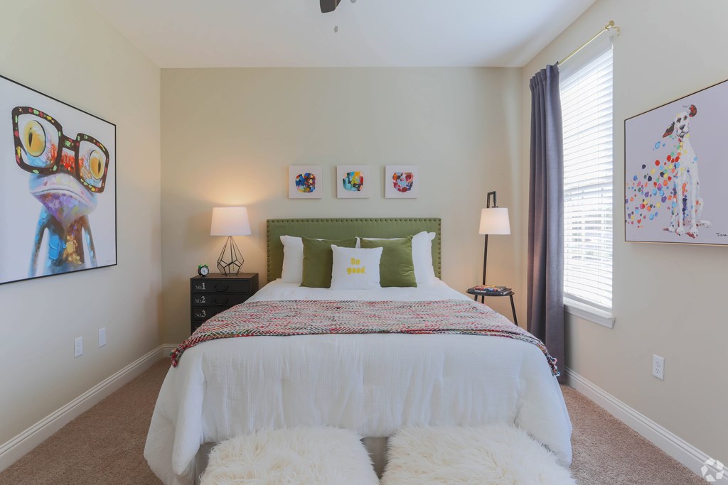A bedroom with a white bed and two white fluffy bedsheets.
