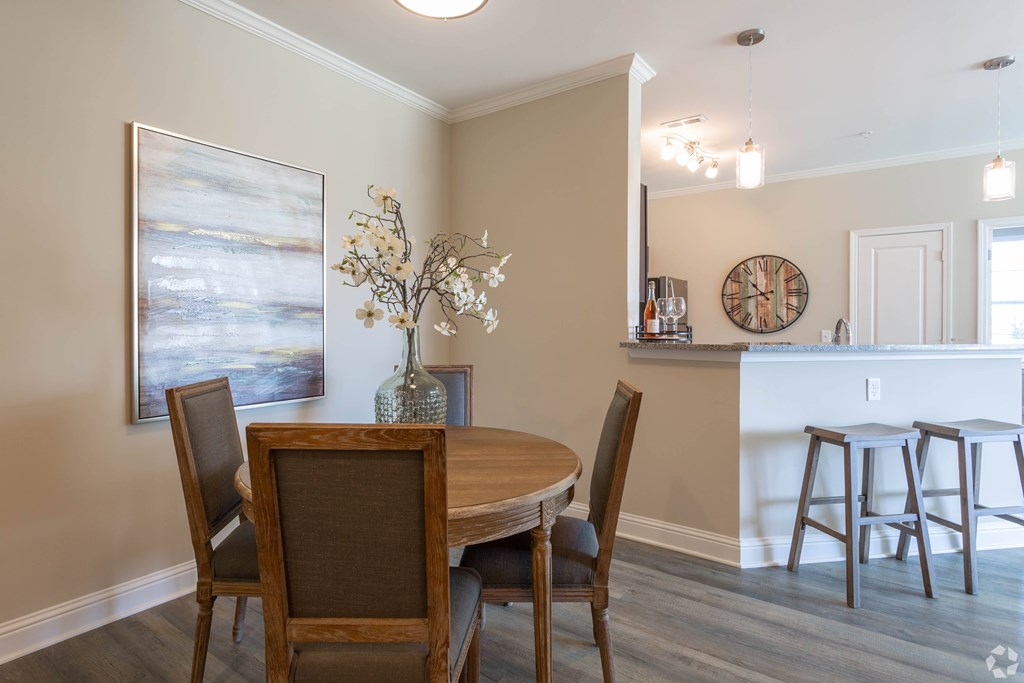 A dining room with a wooden table and chairs.