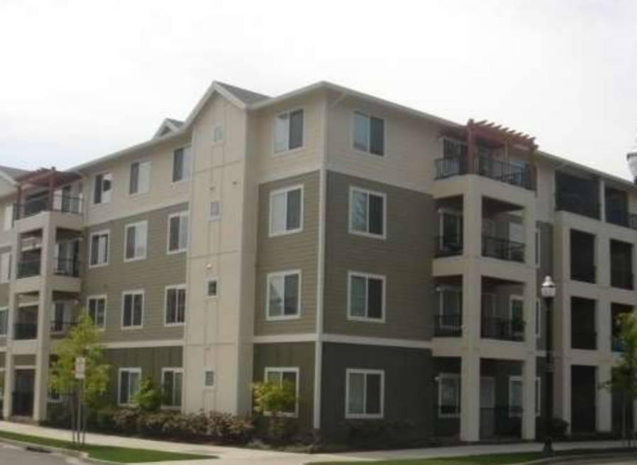 Apartment building with balconies and multiple windows.