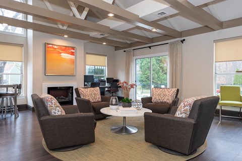A living room with brown chairs and a fireplace.