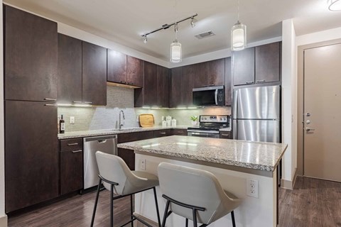 A kitchen with brown cabinets and a granite countertop.