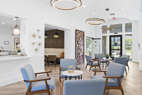 A living room with blue chairs and a wooden floor.