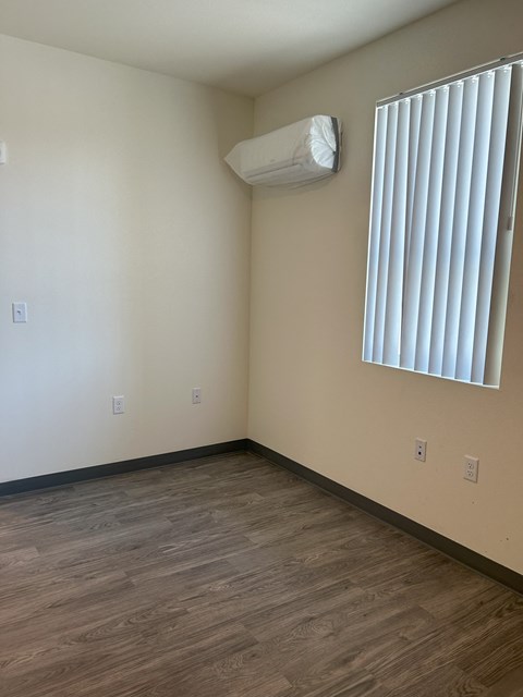 A room with a window and a wall-mounted air conditioner.