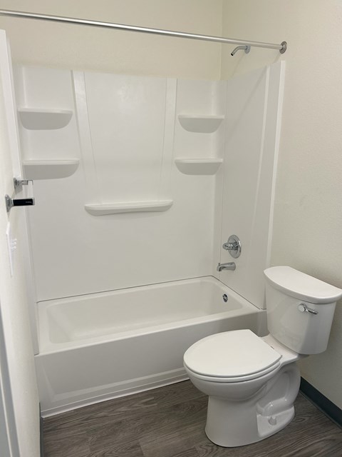 A white toilet is next to a white bathtub in a bathroom.