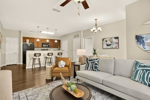 A living room with a couch, chair, and a table with a pineapple on it.