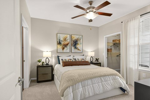 A bedroom with a large bed and a ceiling fan.