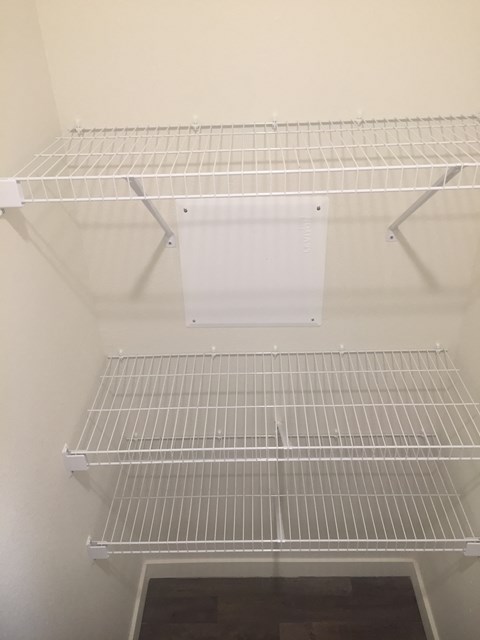 Empty white shelves in a pantry.