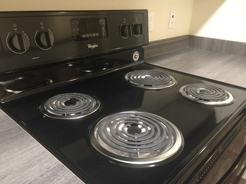 A black stove top with four burners and a control panel.
