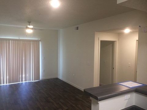A room with wood floors and a table in the middle.