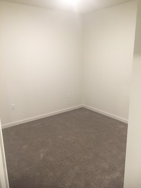 A room with a carpeted floor and white walls.