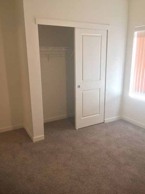 A white door is open to a room with a carpeted floor.