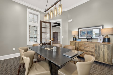 A dining room with a black table and chairs.