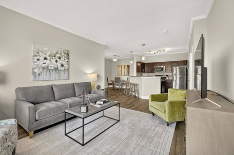 A living room with a grey couch, a coffee table, and a painting on the wall.