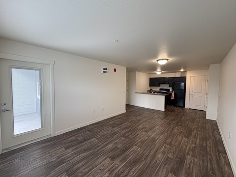 A room with wooden flooring and white walls.