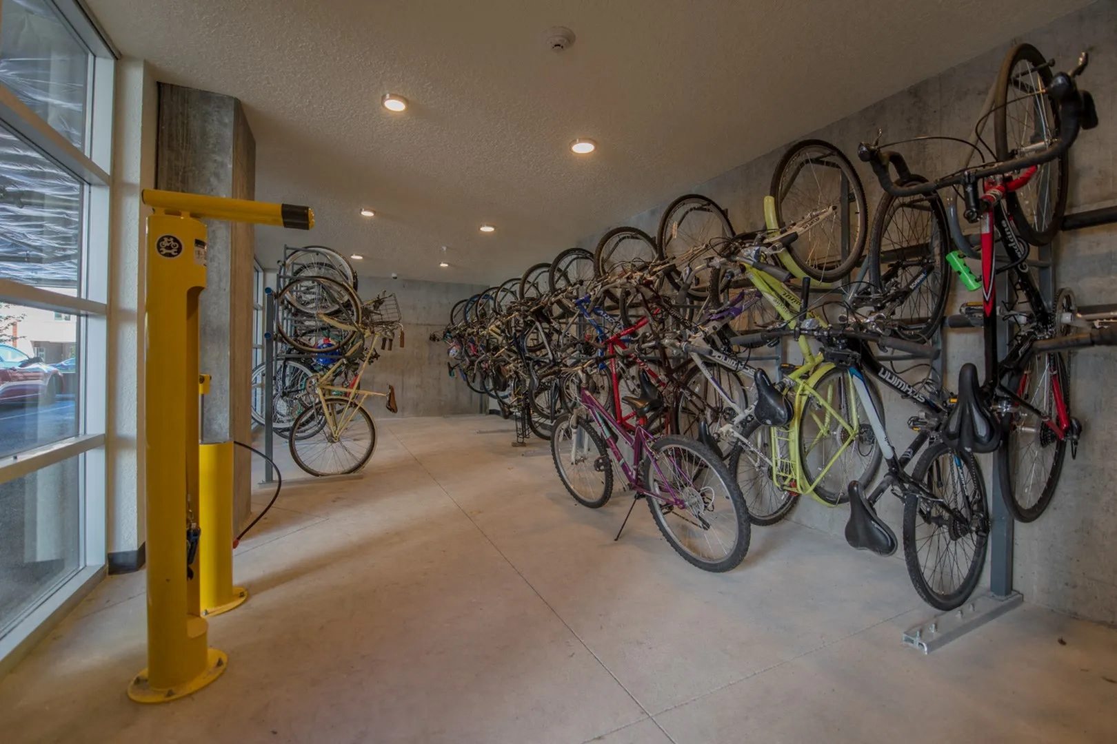 A yellow bike rack with many bikes on it.