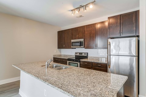 a kitchen with a granite counter top and stainless steel refrigerator
