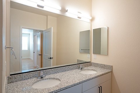 A bathroom with a large mirror above a double sink vanity.