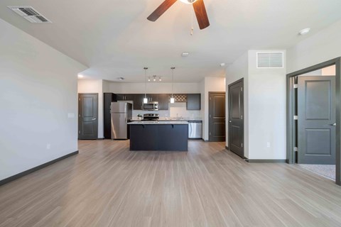 A modern kitchen with a wooden floor and a ceiling fan.