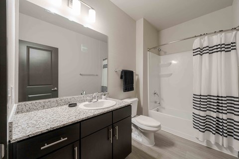 A bathroom with a sink, toilet, and bathtub.