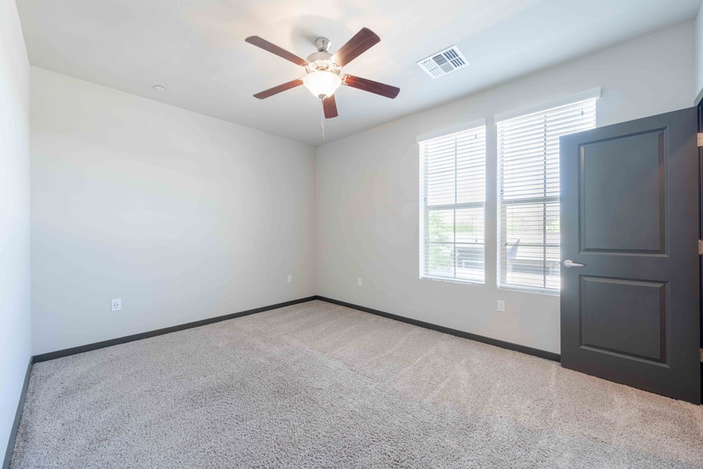 Large bedroom with a ceiling fan.