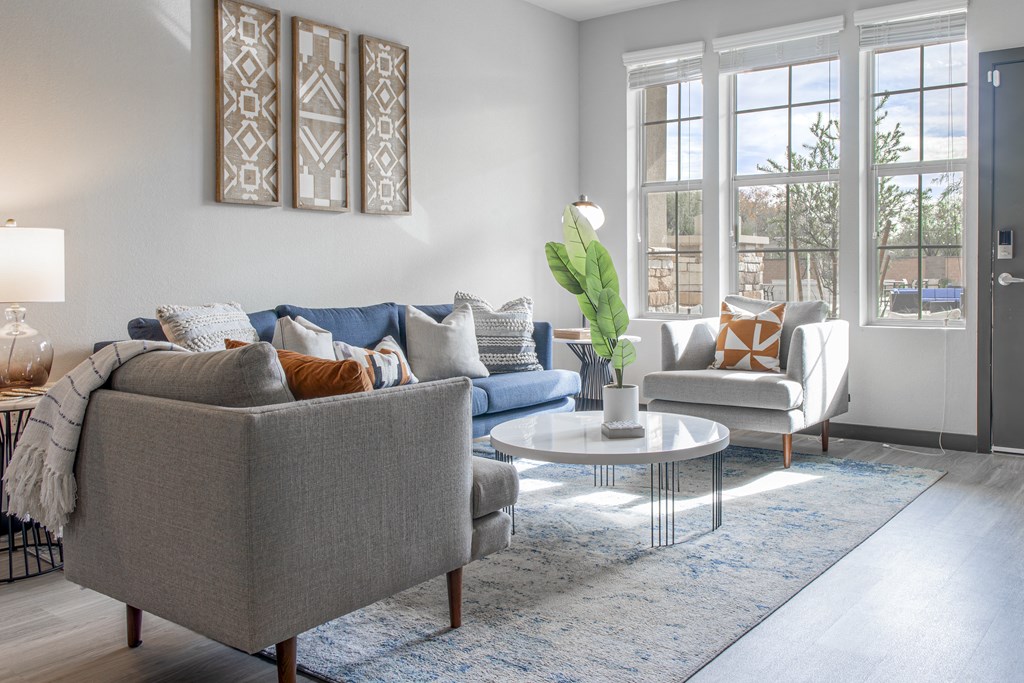 a living room with couches and chairs and a rug