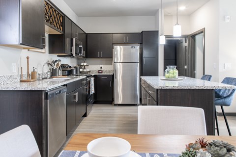 an open kitchen with stainless steel appliances and a dining table