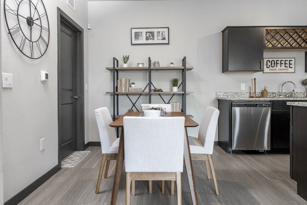 a dining room with a table and chairs and a kitchen with a dishwasher