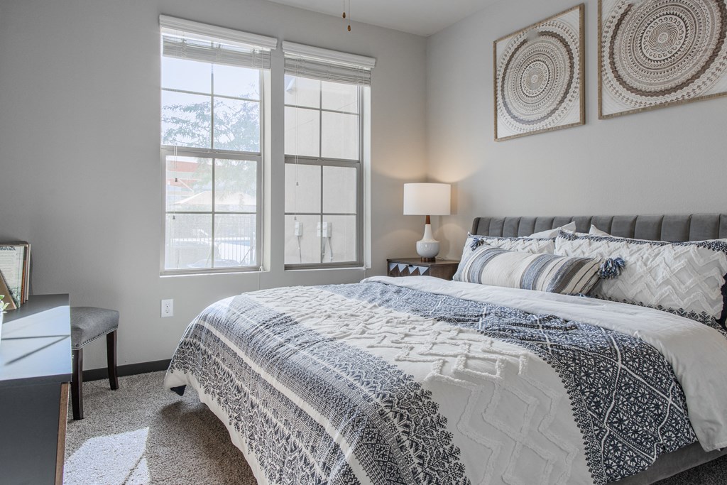 a bedroom with a bed and two windows
