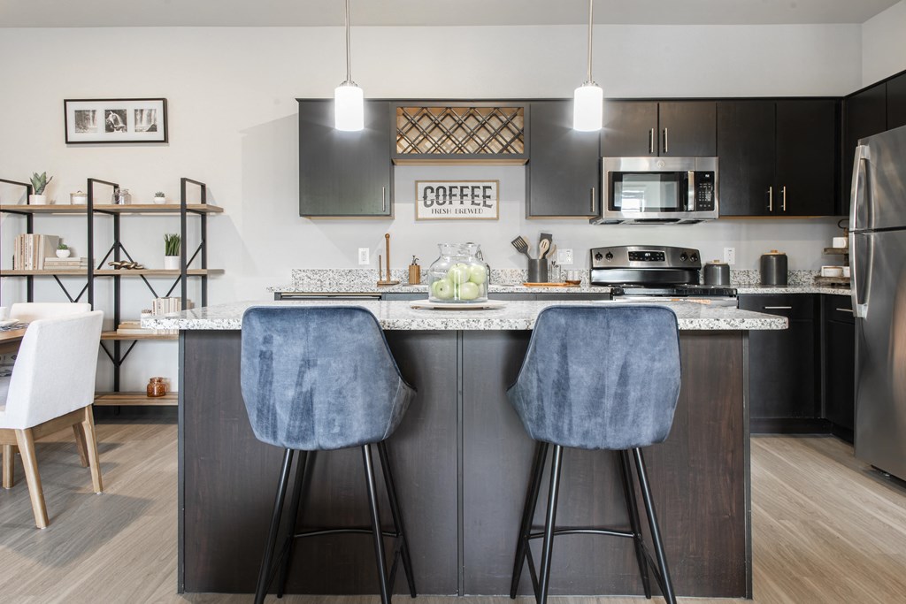 a kitchen with an island with two bar stools