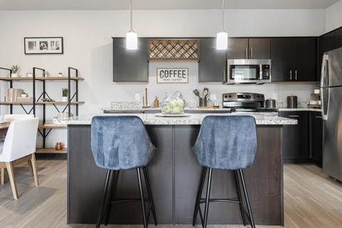 a kitchen with an island with two bar stools