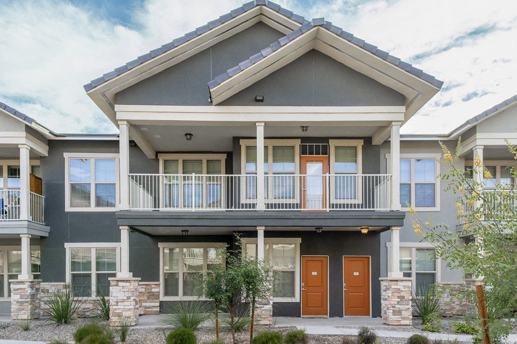 the front of a building with two doors and a balcony
