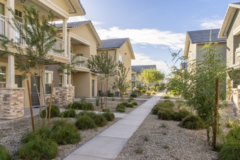 an empty sidewalk in front of a row of buildings