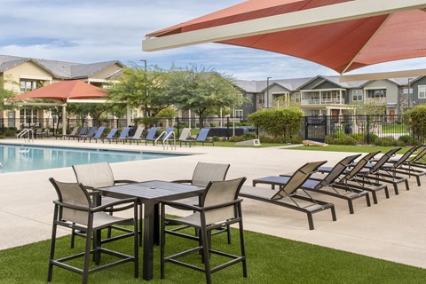 our apartments have a pool and a patio with chairs and tables