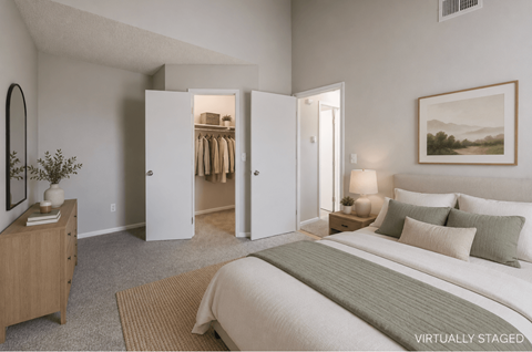 A bedroom with a large bed, a dresser, and a mirror.