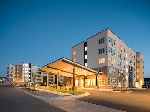 A modern building with a parking lot in front.