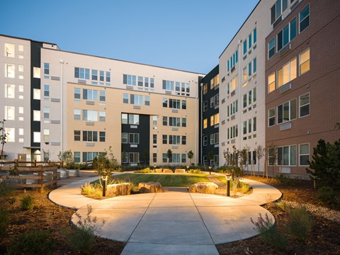 A modern building complex with a circular courtyard in the foreground.