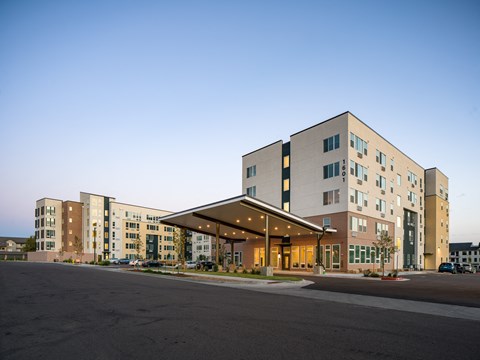 A large, modern building with a parking lot in front.