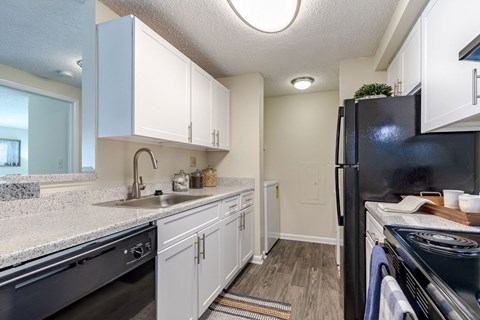 a kitchen with white cabinets and black appliances