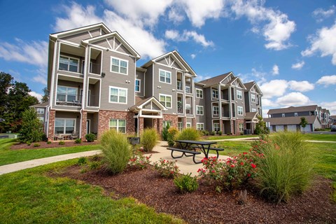 an exterior view of an apartment building with a picnic table