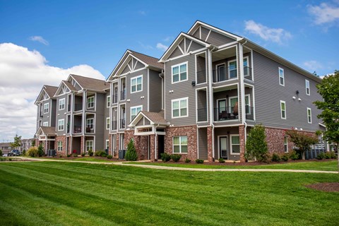 an apartment building with green grass in front of it