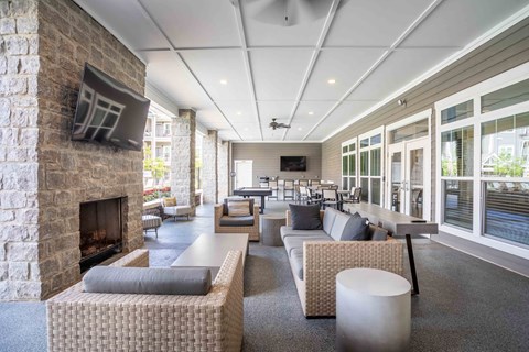 outdoor lounge with couches and chairs and a fireplace