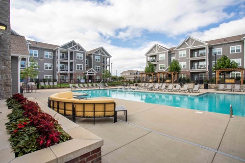 an outdoor swimming pool with an apartment building in the background