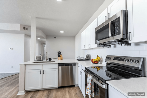 A kitchen with white cabinets and stainless steel appliances.