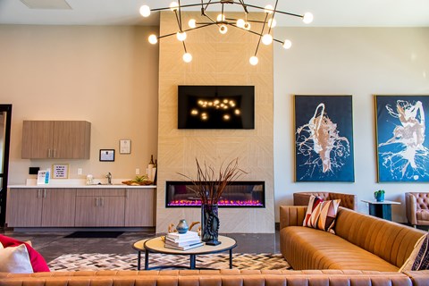 A living room with a fireplace and a painting on the wall.