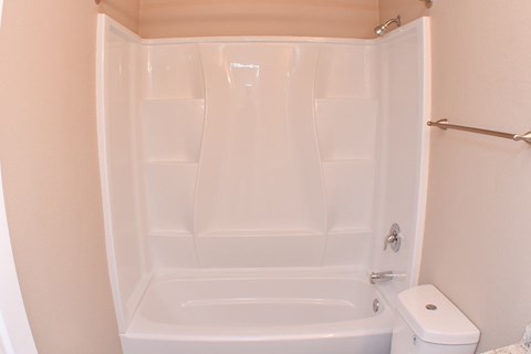 A white bathroom with a toilet and a bathtub.