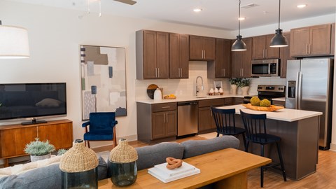 A modern kitchen with a blue chair and a wooden table.