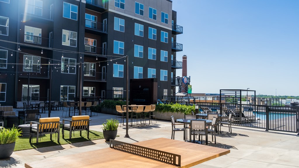 A sunny day at the rooftop patio of a modern apartment building.