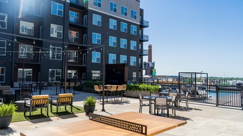 A sunny day at the rooftop patio of a modern apartment building.